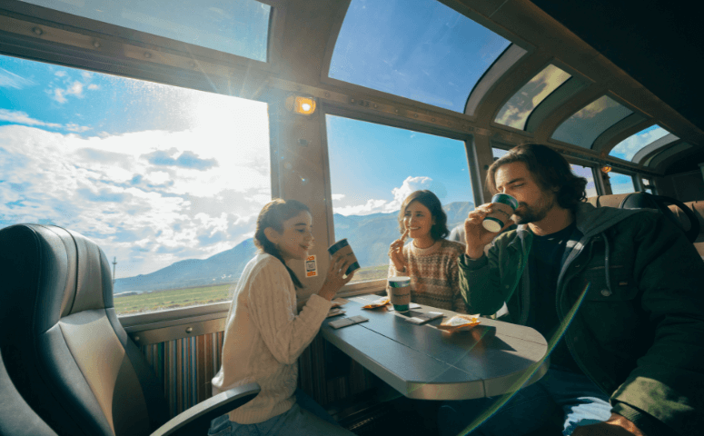 family is sitting and enjoying the view out of the panoramic windows while drinking a beverage