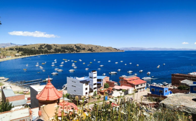 City located at the coast and many boats of different sizes on lake titicaca with Exploor Peru