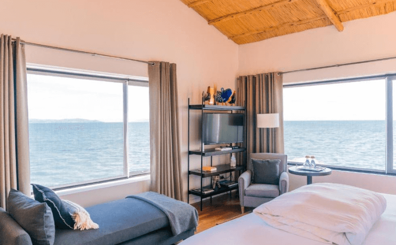 luxurioeses zimmer mit zwei betten und zwei grossen fenstern mit blick auf den titicacasee