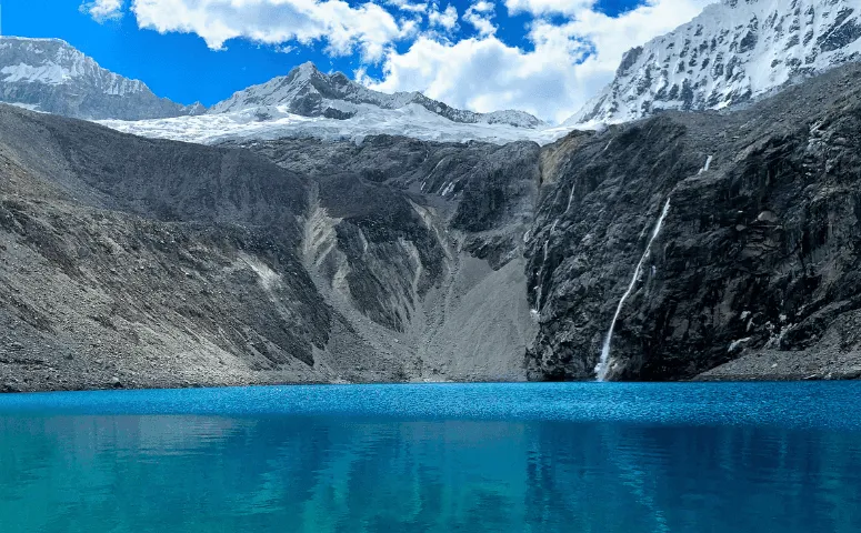 crystal clear lake surrounded by snow-capped mountains 