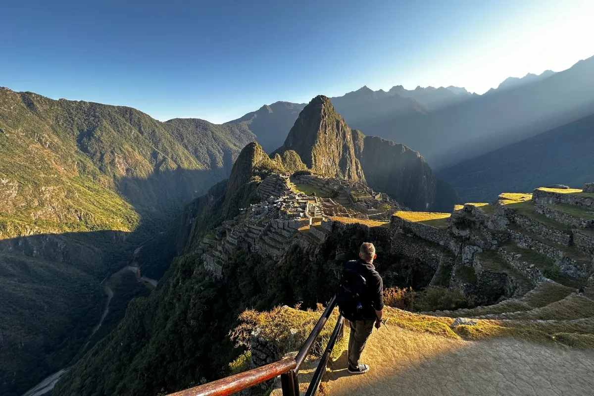 Traveler standing in front of machu picchu ruins with Exploor Peru