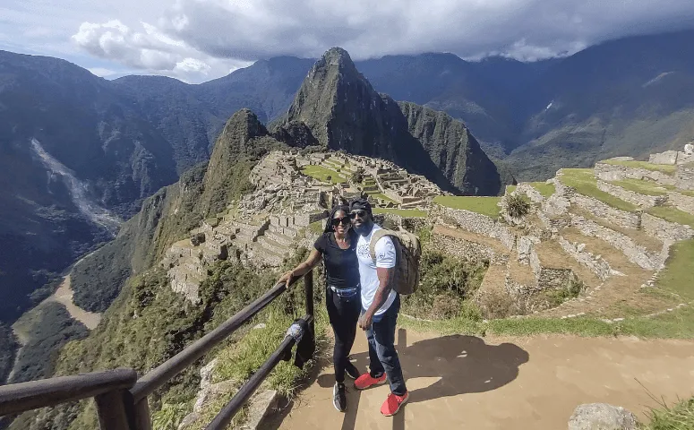 pareja de negros frente a las ruinas de machu picchu